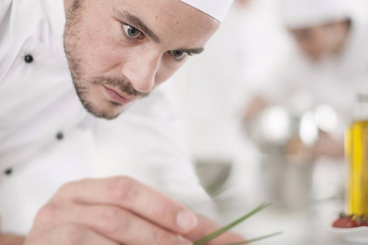 A private chef in Toronto finishing the cooking of a dish A private chef in Toronto cooking a dish